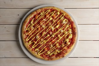 Top view of pizza with sun-dried tomatoes and mustard sauce