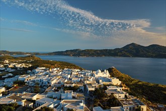 View of Plaka village on Milos island with traditional greek white houses on sunset. Plaka town,