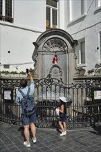 BRUSSELS, BELGIUM, MAY 31, 2018: Tourist taking pictures in front of famous tourist attraction of