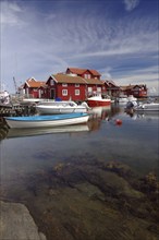 Small harbour and transparent clear harbour basin, red wooden houses, cosiness, tourism, Käringön,