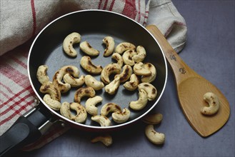 Cashew, roasted cashew kernels in pan with ladle