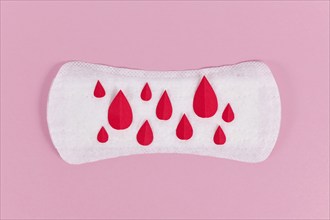 Female period concept with panty liner with symbolic paper blood drops on pink background