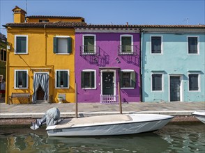 Colourful houses on the canal, canal with boats and colourful house facades, Burano Island, Venice,