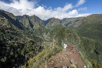 Tourist at a viewpoint, view from the Miradouro dos Balcões, densely overgrown steep mountains,