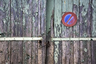 Old weathered wooden gate with old no-stopping sign, Provence, France, Europe