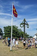 Traditional midsummer celebration with dancing around the maypole at Smygehuk, Smygehamn,