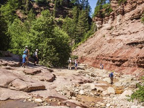 GEOPARC Bletterbach canyon, layers of sediments, stratum, people hike inside the gorge, Aldein,