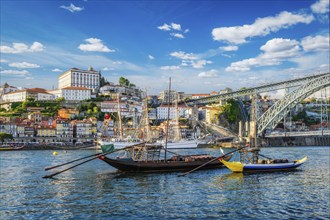 View of Porto city and Douro river with traditional boats with port wine barrels and sailing ship