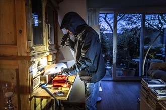 Symbolic image of a burglary, perpetrator has broken into a flat from the garden side and is