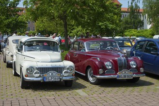 Two vintage cars, one red and one white, parked next to each other, vintage car, Volvo PV 544,