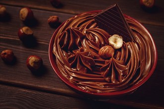 Chocolate nut paste, mousse, pasta, in a cup, on a wooden table, top view, selective focus, no