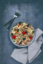 Fusilli pasta salad with canned tuna, cherry tomatoes and olives, parmesan, microgreens, homemade,