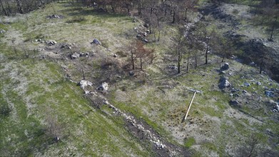 Drone image, above Kiotari, Vast barren landscape with remains of burnt trees and boulders after a