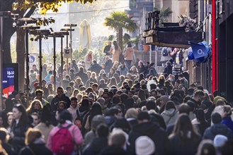 Crowds of people out and about in the Königstraße shopping street. The shops in the pedestrian zone