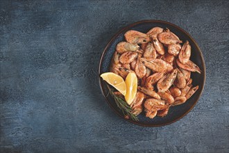 Fried shrimp, with shell and head, unpeeled, size 70-90, on a blue background, homemade, no people