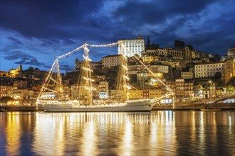 View of Porto city and Douro river with sailing ship from famous tourist viewpoint Marginal de Gaia