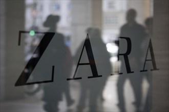 Company logo of the textile retail chain Zara, passers-by reflected in the shop window in Berlin,