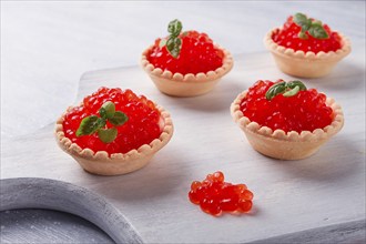 Tartlets with red caviar, on a light background, close-up, top view, no people