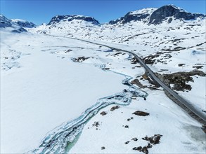 Aerial view of snow-covered high mountain landscape, Haukelivegen road, E134, melting blue ice on