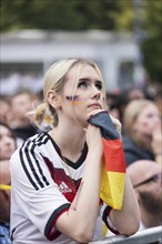 A woman watches the football match in the fan zone at the Brandenburg Tor during the quarter-final