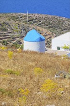 Traditional windmill overlooking Sifnos coast, Sifnos Island, Cyclades Islands, Greece, Europe