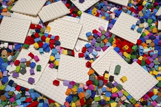 Different coloured Lego bricks and building boards chaotically distributed, Copenhagen, Denmark,