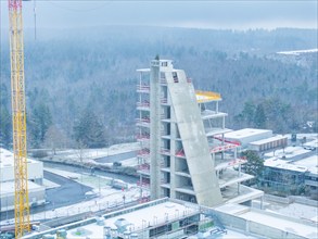 Unfinished building in winter with crane and snow-covered surroundings, Nagold, Häfele, Black