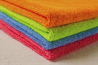 A stack of colored cloth, microfiber, for cleaning the house, on a white table, horizontal, no