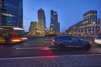 Office building, Potsdamer Platz railway station, cars and bus with motion blur at the blue hour,