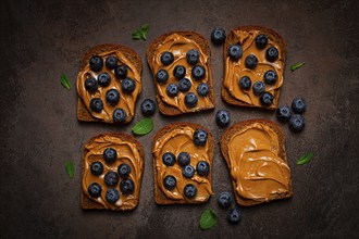 Rye bread with peanut paste and fresh blueberries, top view, no people