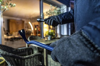 Symbolic image of a burglary, perpetrator spies on a flat from the garden side