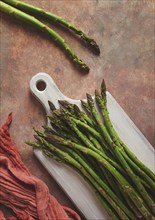 Bouquet of fresh asparagus, on an abstract background, top view, rustic, no people