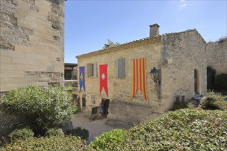 Building with banner and flags, mountain village, Les Baux-de-Provence, Alpilles, Alpilles,