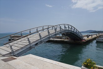 Arched bridge over the water with flower arrangement, surrounded by harbour and sky, Arched bridge,