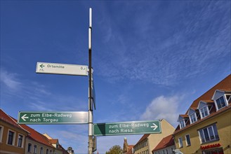 Signpost to the Elbe cycle path to Torgau and Riesa against a blue sky with cirrostratus clouds,