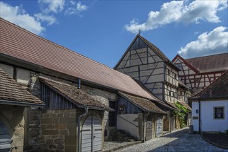 Former storage rooms, barns from the 15th century, in the historic fortified church, Hüttenheim,