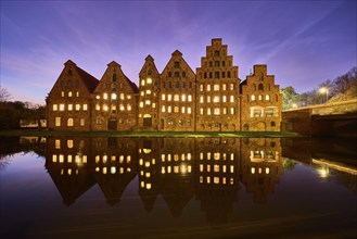 Salt storehouse, historic brick buildings, illuminated windows, symmetrical reflections on the