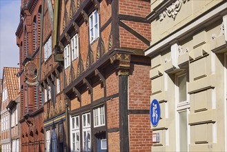 Facades of old half-timbered houses with a nose sign in the historic centre of Stade, Hanseatic