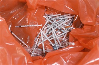 Disposed syringes are seen after a health worker inoculates students with a dose of a Covid-19