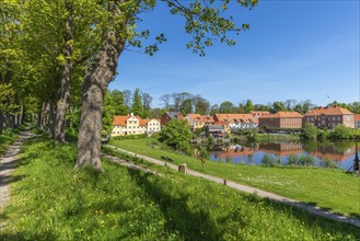 Old town of Nyborg, moat around the medieval town, houses at the castle wall, water reflection,