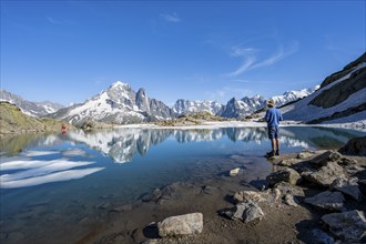 Mountaineer in front of mountain landscape with mountain lake, tourist at Lac Blanc with water