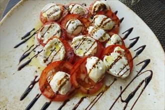 Italian cuisine, Insalata Caprese, vine tomatoes, buffalo mozza arranged on a plate, balsamic