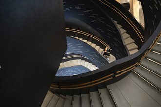 Woman on spiral staircase printed with Finnish words, Oodi Central Library and Cultural Centre,