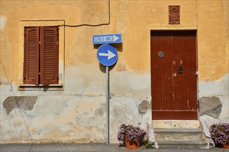 House wall, one-way street sign, brown door, brown shutters, flower pot, Rinella, town on the south