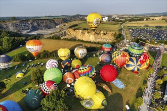 Colourful hot air balloons at mass launch, crowd on fairground, Hot Air Balloon Festival, 26th