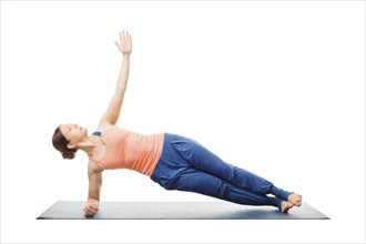 Hatha yoga, sporty fit woman doing yoga asana Vasisthasana, side plank pose modification for wrists