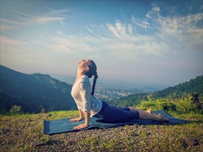 Yoga outdoors, woman practices Ashtanga Vinyasa yoga Surya Namaskar Sun Salutation asana Urdhva