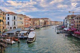 VENICE, ITALY, JUNE 27, 2018: Grand Canal with boats, vaporetto and gondolas on sunset from Rialto