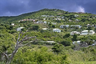 Threatening dark rain cloud over houses on hillside on the east side of the Dutch island part of