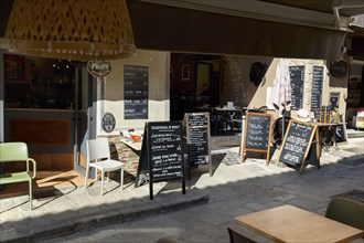 Many signs with Corsican specialities in front of a restaurant, old town of L'Île-Rousse, Ile